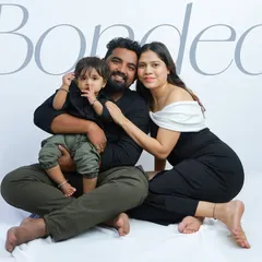 Bonded by love, framed forever. This portrait on a clean white backdrop has a modern and timeless feel, perfectly showcasing the connection of this beautiful family of three.