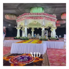 A beautiful Vidhi Mandap setup for a Haldi ceremony. The design incorporates a traditional floral canopy, elegant seating, and a custom rangoli made of fresh flower petals.