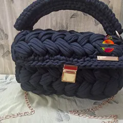 The black t-shirt yarn handbag, a timeless and elegant accessory. The deep black color makes the gold hardware pop, creating a sophisticated look for any occasion.