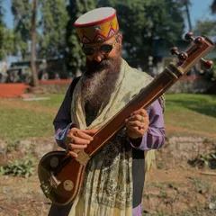 Holding a Taanpura in a peaceful outdoor setting. Like yoga, music teaches us balance, and the harmony of this instrument is a reminder of the inner harmony we seek in our lives.