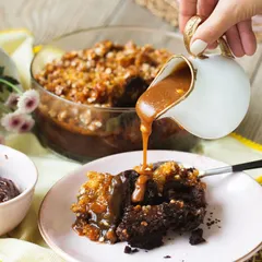 The ultimate indulgence. I'm pouring warm, homemade salted caramel sauce over a serving of my chocolate trifle, which is layered with dark chocolate cake and crunchy almond praline.