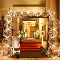 For a 25th anniversary, I designed this beautiful and warm welcome gate. The arch is constructed from interconnected wireframe spheres wrapped in fairy lights, creating a magical, glowing entrance for the celebrating couple and their guests.