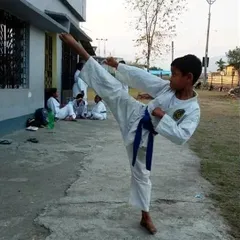 A young blue belt student practices his side kick. Each belt level represents a new stage of learning and commitment. I ensure every student works hard to achieve their goals.