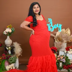 A simple and sweet gender reveal for a baby boy. The mom-to-be's red dress and the blue sign make for a vibrant and happy photo.