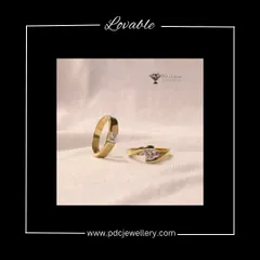 A lovable and elegant pair of solitaire rings for a couple. The gent's ring features a princess-cut diamond in a wide gold band, while the lady's ring has a delicate twist design, both showcasing a single, beautiful stone.