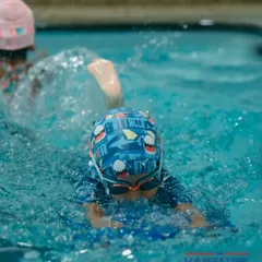 Practice makes perfect. A young swimmer uses a kickboard to build leg strength and improve his form, a fundamental part of our training program.