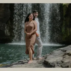 A stylish pose with the couple standing back-to-back in front of a waterfall. This composition is both modern and romantic, highlighting their connection.