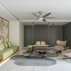 This formal living space from my Park West project embodies my design philosophy of creating tranquil, sophisticated environments. I used a layered neutral palette, punctuated by the soft green of the sofa and the warmth of a custom brass partition, to create distinct zones that flow into one another. The indoor swing adds a touch of playful serenity, making the space feel both grand and intimately personal.