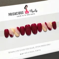 A beautiful custom press-on set in a rich maroon, accented with nude nails and a delicate silver glitter swirl.