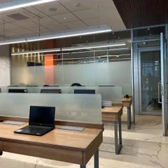 An open-plan workspace designed for collaboration at the Begur & Partners office. We used frosted glass partitions to provide a sense of privacy without sacrificing the flow of natural light from the large windows.
