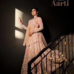 A stunning solo portrait of the bride-to-be in her intricate lehenga. The dramatic lighting highlights her glowing expression and the detailed craftsmanship of her engagement attire.