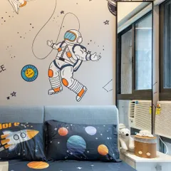 A close-up of a space-themed kids' room. The astronaut wallpaper and planet-themed bedding are easy to change as the child's interests evolve, while the furniture remains timeless.