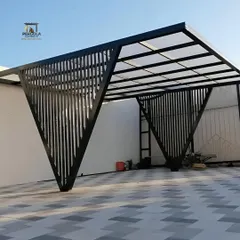 A modern car parking shelter with a unique, angular design. The structure uses vertical slats for the supports and a translucent polycarbonate roof, providing protection from the elements while maintaining a stylish, sculptural look.