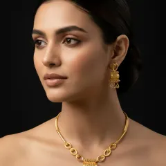 A close-up of the gold necklace set on a model, emphasizing its luxurious and classy feel. The warm glow of the gold complements the skin, showcasing how our jewellery is designed to enhance natural beauty.