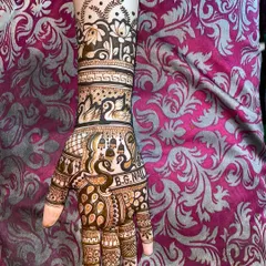 A beautiful arm design featuring a variety of traditional motifs. You can see peacocks, swans, and temple bells, all woven together with intricate patterns.