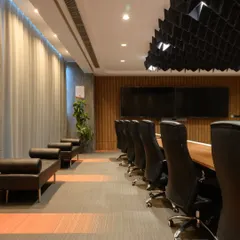 Here's another angle of the conference room, showing the dual screens for video conferencing and the comfortable leather seating. I subtly integrated the company's brand colors into the carpet design to tie the whole look together.