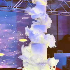 This was a dream to create. A six-foot-tall wedding cake designed to look like a flowing gown, adorned with delicate white feathers. It's a perfect example of how I blend artistic vision with baking to create a centerpiece that tells a unique love story.
