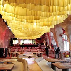 This photo shows the "before" of a ceiling transformation. The simple yellow fabric waves were the base layer for a much more intricate design, demonstrating how we build our installations in stages to achieve a final, spectacular look.