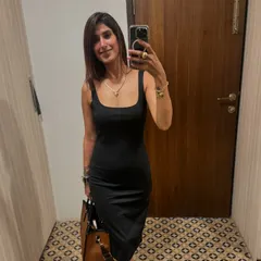 This is my go-to little black dress. The simple, body-hugging silhouette is incredibly versatile. Here, I've paired it with a classic tote bag for a look that's perfect for a networking event or a dinner out.
