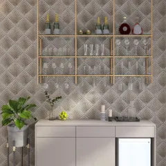 A glamorous and minimalist bar area with a geometric-patterned wallpaper, floating gold-finish shelves for glasses, and a simple console with a built-in mini-fridge.