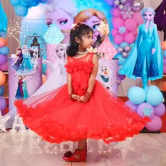 The birthday girl looking radiant in her red dress against the magical Frozen backdrop. We pay close attention to every detail, from the decor to ensuring the lighting is perfect for stunning birthday portraits.