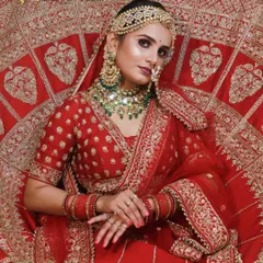 The quintessential red bridal lehenga, a symbol of love and tradition. We created a flawless HD makeup look to match, ensuring our bride looks absolutely stunning from every angle.