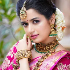Another beautiful portrait of Ashika Ranganath, showcasing the fine details of her makeup and the traditional floral hair arrangement.