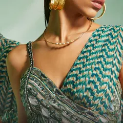 A detailed view of the green Verity blouse, highlighting the combination of beadwork, threadwork, and mirror embellishments.