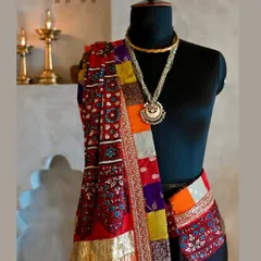 A detailed shot focusing on the pallu, where the vibrant red of the Ajrakh block-print and the multi-colored patchwork border truly shine. The layering of textures is central to my design philosophy.