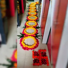 A beautiful floral pathway created with circles of yellow and pink flower petals. This design is perfect for guiding guests into a celebration, ending with an auspicious swastika symbol made of marigold petals.