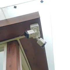 Here are two Hikvision bullet cameras installed neatly under an eave. This placement protects the cameras and provides a clear view of the side of the house.