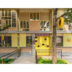 The facade of the Mathru Centre for Developmental Disabilities. We used reclaimed windows from another project, painting them a bright, cheerful yellow to create a welcoming and visually stimulating entrance. The ramp ensures the building is accessible to all.