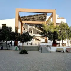 The entrance to the Vidyamandir School in Palanpur showcases our approach to creating welcoming and functional educational architecture. The design uses strong geometric forms and open, sheltered walkways that lead into the campus, providing a transition from the outside while offering protection from the elements.
