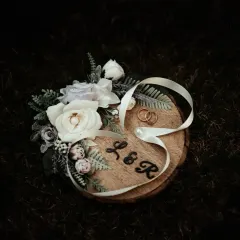 The wedding rings, a symbol of eternal love, beautifully arranged on a custom wooden platter. We capture the small details that hold big meanings.