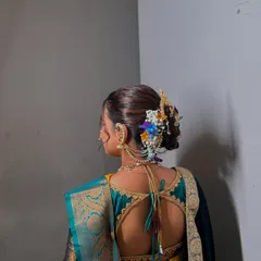 A detailed shot of a traditional Maharashtrian bridal bun, complete with intricate floral arrangements and classic hair accessories.