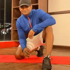 Kneeling on the mat, ready for a workout. Fitness is my passion, and I'm dedicated to helping you find a routine you love.