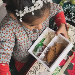 The moment of discovery. A young baker opens her DIY cookie kit, ready to start decorating. It’s a wonderful way to get creative during the festive season.