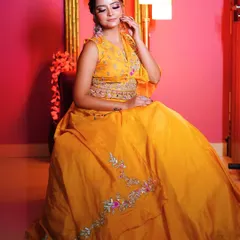 A seated portrait that highlights the intricate belt detail and the beautiful fall of the lehenga.