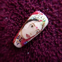 A close-up of the Radha Rani portrait nail. You can see the fine details in the jewelry, facial expression, and traditional bindi, all painted by hand.