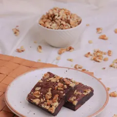 Our Walnut Brownie is a timeless classic. The rich, fudgy texture of the brownie is perfectly complemented by the earthy crunch of high-quality walnuts baked right in.