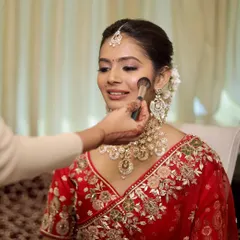 A close-up of my skin-focused technique. I believe in enhancing, not hiding. Here, I'm applying a light dusting of powder to set the makeup, ensuring the bride's natural skin texture and glow remain the hero of her wedding day look.