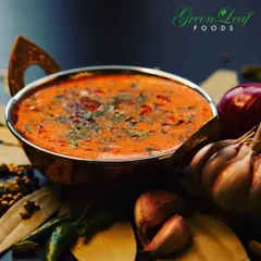 A close up of a classic Indian curry, rich with spices like bay leaves, cardamom, and garlic. I take great care in balancing these flavors to create authentic main courses that are the heart of any wedding meal.