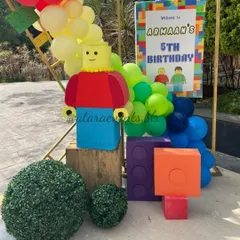 A cheerful LEGO figure and oversized blocks create an inviting entrance and a fantastic photo opportunity for guests arriving at the party.