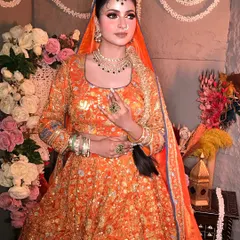 Another angle of this stunning orange lehenga look, showcasing the intricate embroidery and the way the makeup complements the warm tones of the outfit.