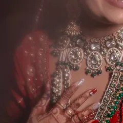 A soft-focus, artistic close-up of the bride's hands, mehndi, and stunning necklace. This shot is all about texture and detail.