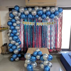 A simple yet striking balloon arch in chrome blue and silver, set against a multi-colored fringe curtain. This is a great way to create a festive photo corner in your living room.