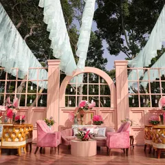 The main lounge from our 'Whispers of the Orient' carnival. We created a stunning pink façade with arched windows and filled the space with plush pink velvet furniture and oriental-inspired floral arrangements.