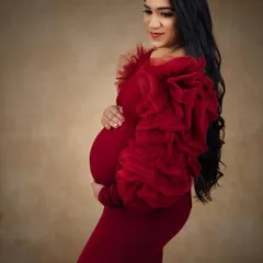 A side profile showcasing the elegant makeup and the beautiful silhouette of the maternity gown. The look is all about celebrating the beauty of pregnancy.