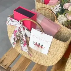 A single bridesmaid hamper, showcasing the personalized card and the stylish floral scarf tied to the handle of the straw bag.