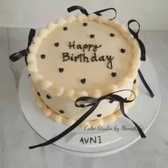 A beautiful minimalistic cake, a style that is very popular these days. This design features simple black hearts and delicate black ribbons on a smooth, white buttercream finish.